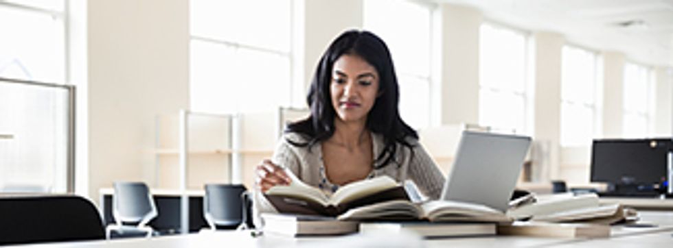 Girl at desk with books and technology