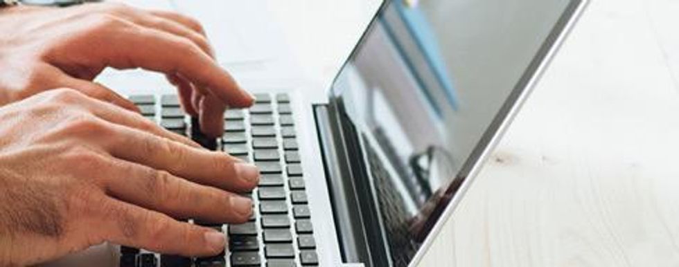 Closeup of hands typing on a laptop