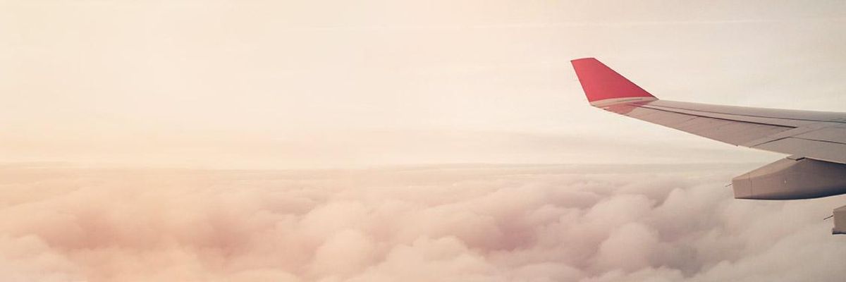 Photo of a plane wing up in the clouds.